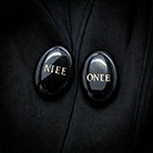 A pair of oval black buttons with gold text

Description automatically generated
